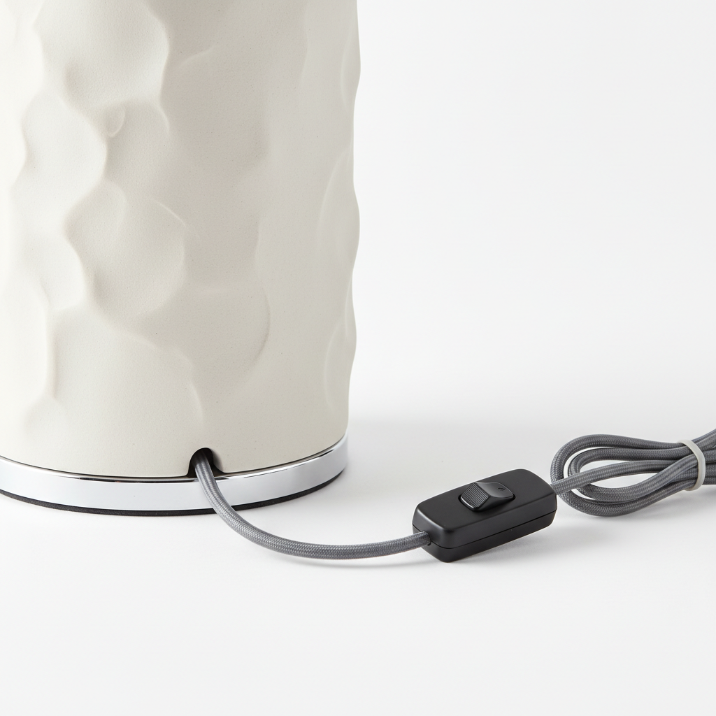 Detail shot of ceramic table lamp showing cord, switch and base texture